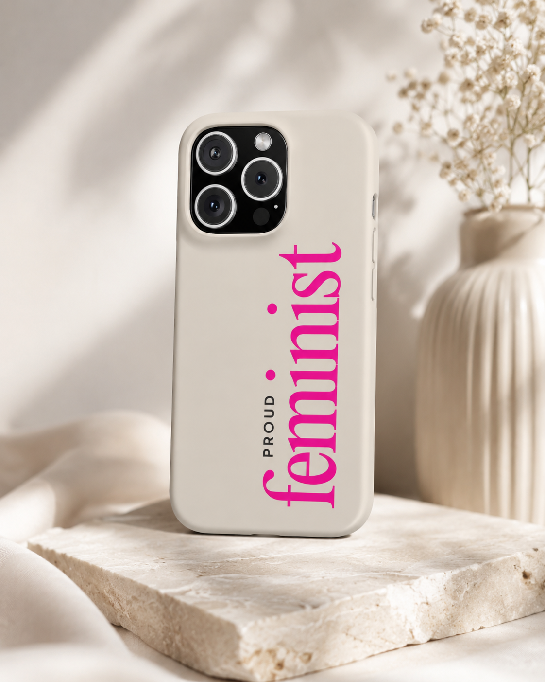 Two cream matte phone cases with vertical pink Proud Feminist typography on a neutral background.