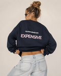 Woman wearing an oversized navy crewneck sweatshirt with a pink and white My Standards Are Expensive back print