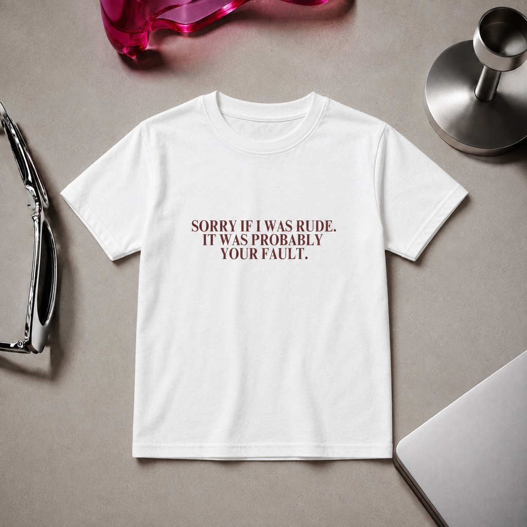 Woman wearing a fitted white “Sorry If I Was Rude, It Was Probably Your Fault” graphic T-shirt with black trousers