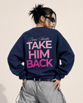 Model wearing a navy Dear Santa Take Him Back sweatshirt with pink back print and silver cargo pants