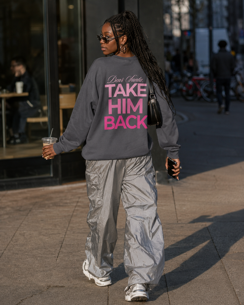 Street-style photo of a charcoal Dear Santa Take Him Back sweatshirt worn with white trousers