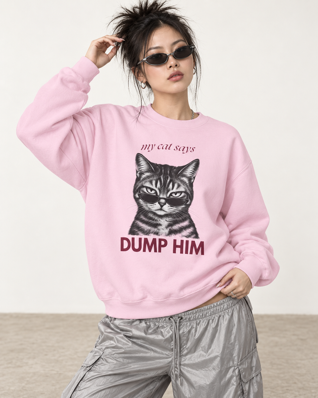 Model wearing a light pink My Cat Says Dump Him sweatshirt with cat and sunglasses graphic