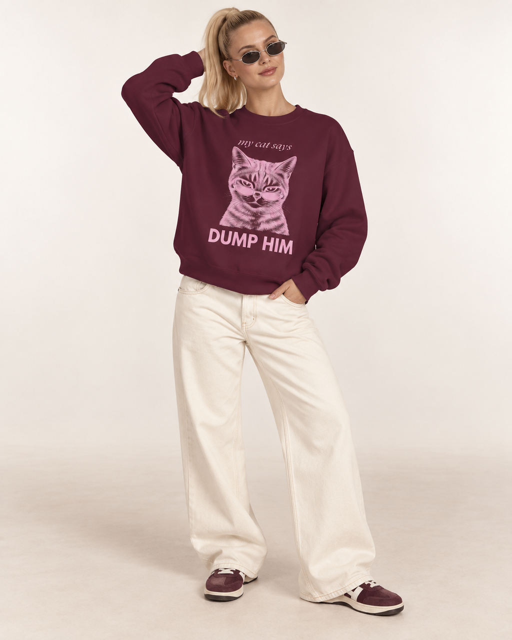 Model wearing a maroon cat graphic sweatshirt with pink Dump Him print