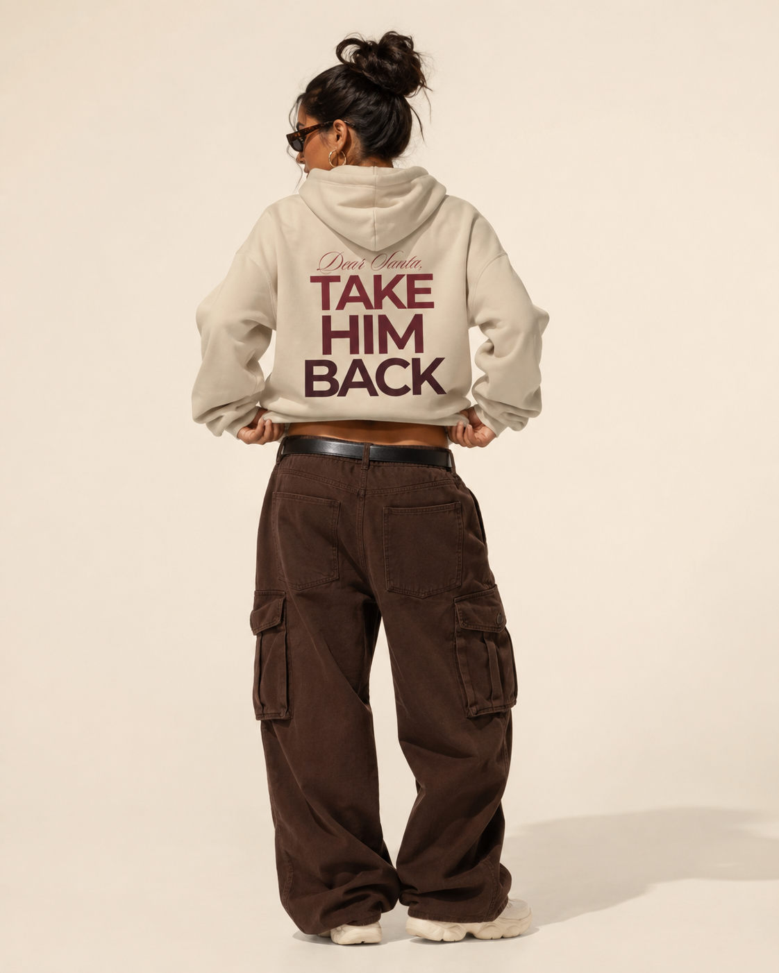 Back view of a cream Dear Santa Take Him Back hoodie styled with silver trousers