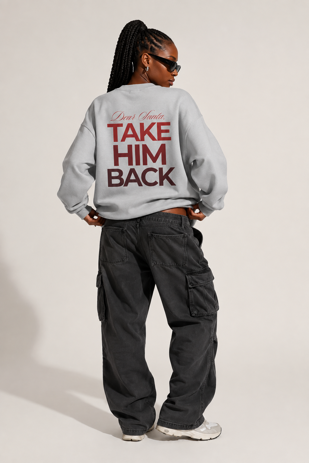 Back view of a light gray Dear Santa Take Him Back hoodie with black cargo trousers