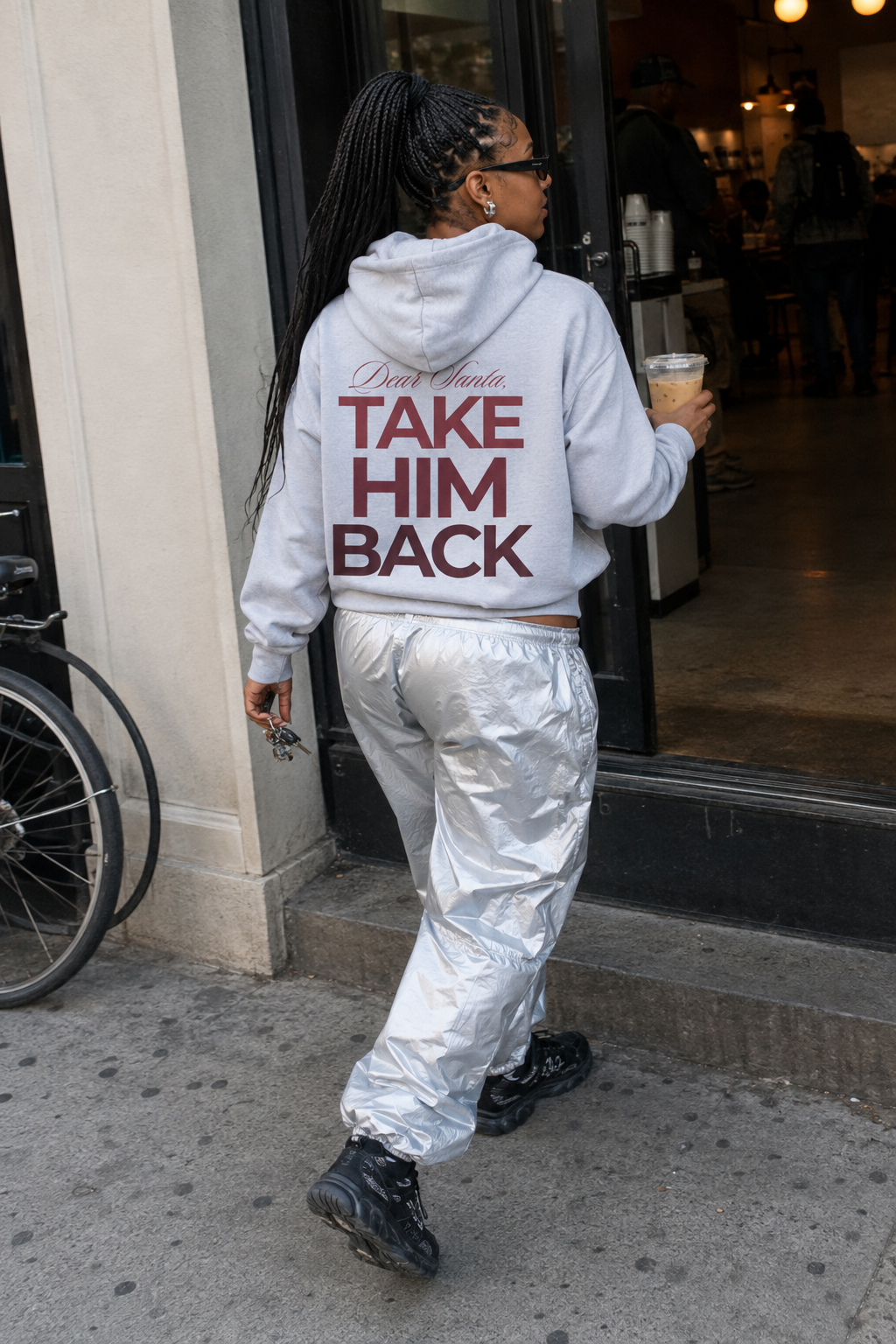 Street-style photo of a light gray Christmas breakup hoodie with red back print